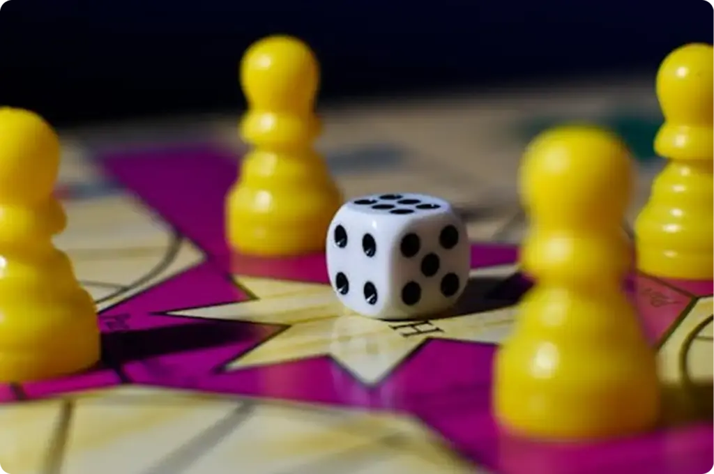 Dobbelstenen omringd door gele speelstukken op een kleurrijk bord, die symbool staan voor strategie, beweging en turn-based gameplay in de setting van een klassiek bordspel